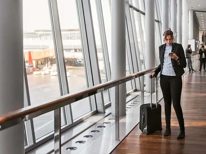 Traveller checking a phone at an airport
